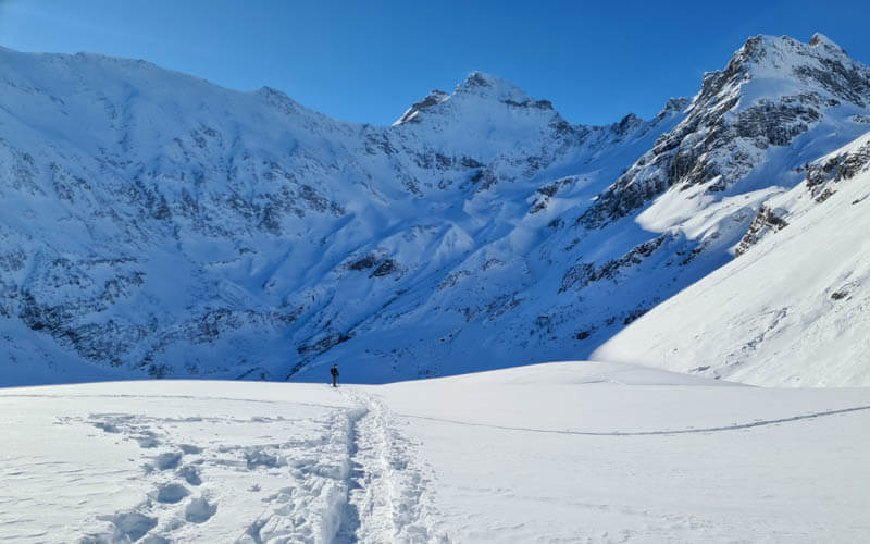 winter hiker on Obererbs snowshoe trail leading to large mountains